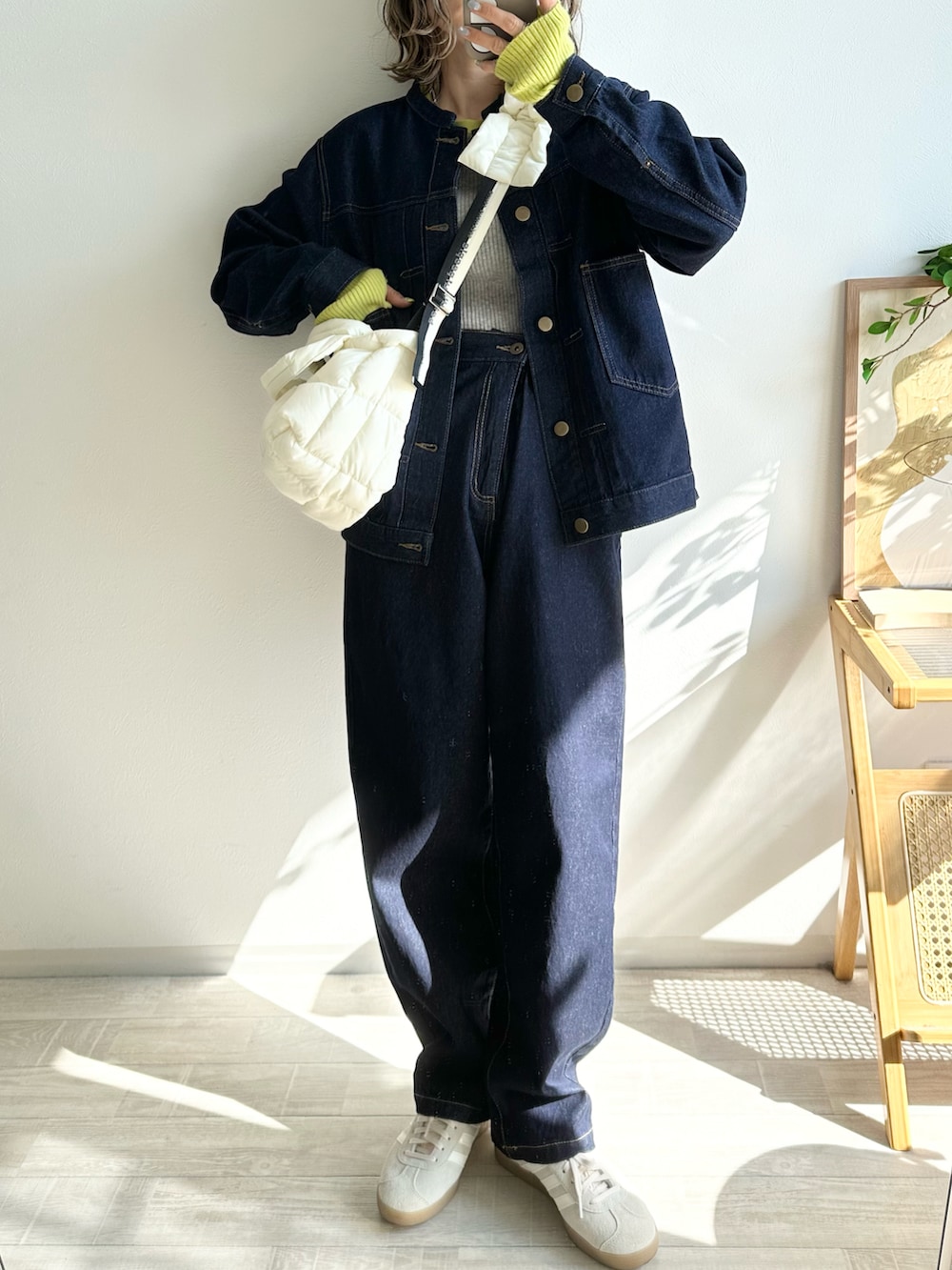 ブルー系のデニムジャケット、ブルー系のデニムパンツ、ホワイト系のショルダーバッグを着用したレディースの冬コーディネートの2枚目の写真