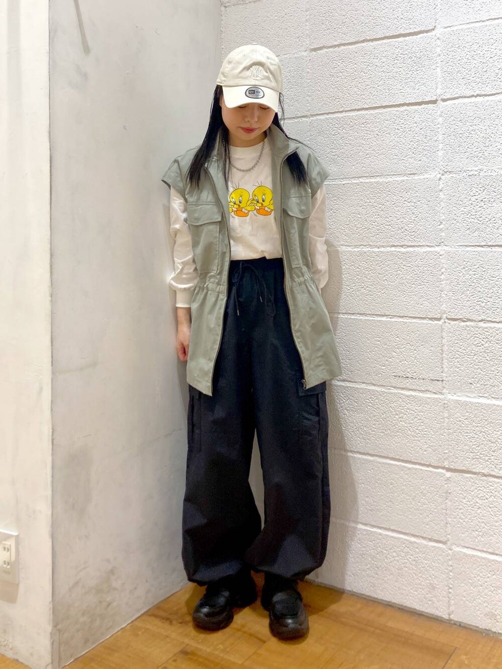 ホワイト系のTシャツ/カットソー、ブラック系のカーゴパンツ、グリーン系のブルゾンを着用したレディースの春コーディネートの2枚目の写真