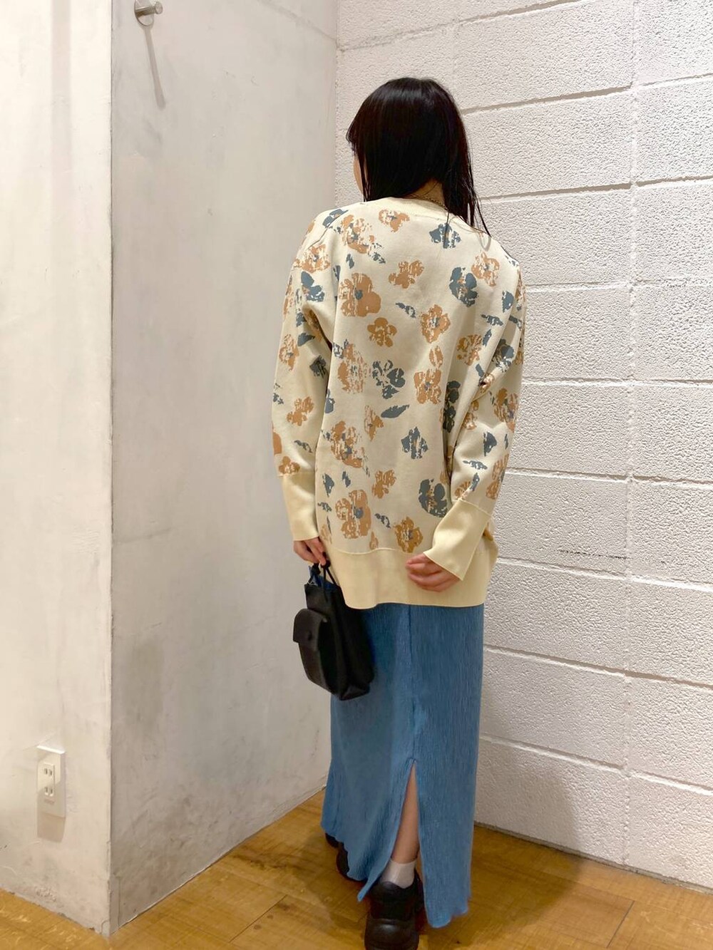 ブラック系のサンダル、ブルー系のスカート、ブラック系のショルダーバッグを着用したレディースの春コーディネートの3枚目の写真