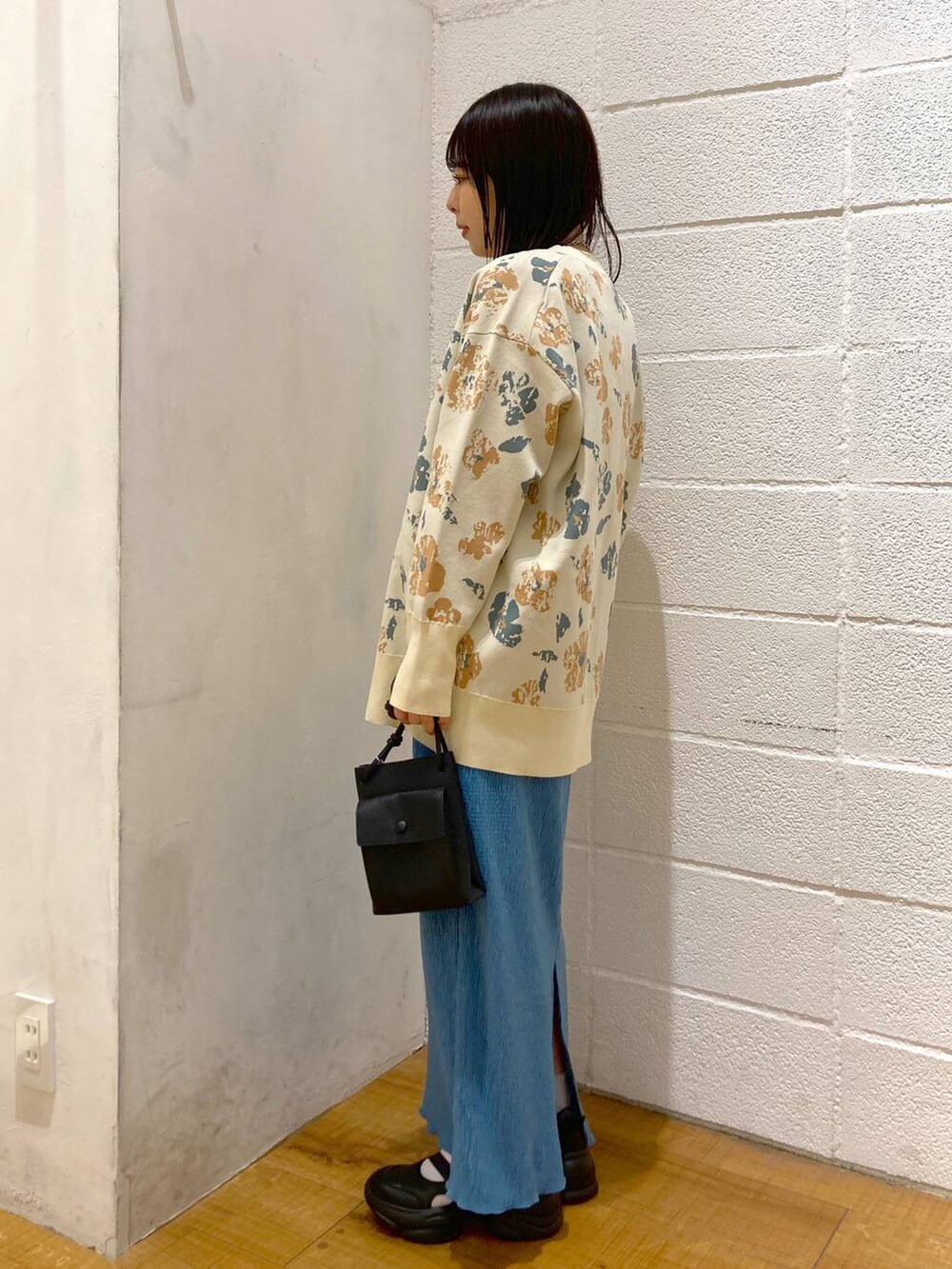 ブラック系のサンダル、ブルー系のスカート、ブラック系のショルダーバッグを着用したレディースの春コーディネートの2枚目の写真