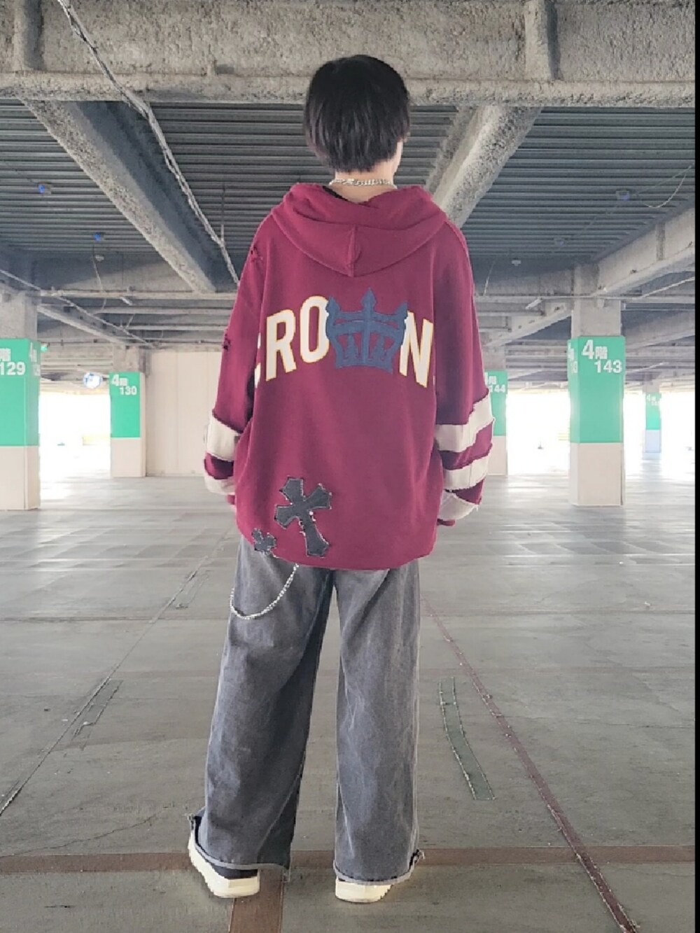 グレー系のデニムパンツ、レッド系のパーカー、ホワイト系のブーツを着用したメンズの秋コーディネートの2枚目の写真