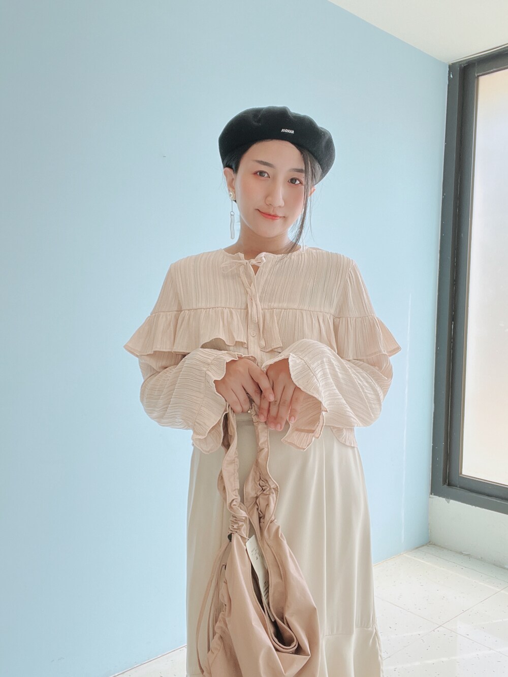 ピンク系のシャツ/ブラウス、ベージュ系のスカート、グレー系のスニーカーを着用したレディースの春コーディネートの5枚目の写真