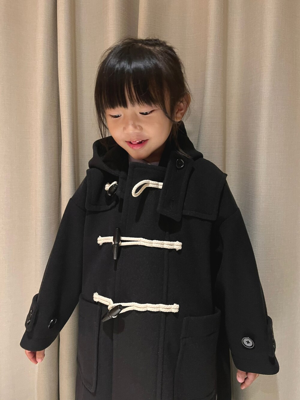 ブラック系のダッフルコートを着用したキッズの冬コーディネートの2枚目の写真