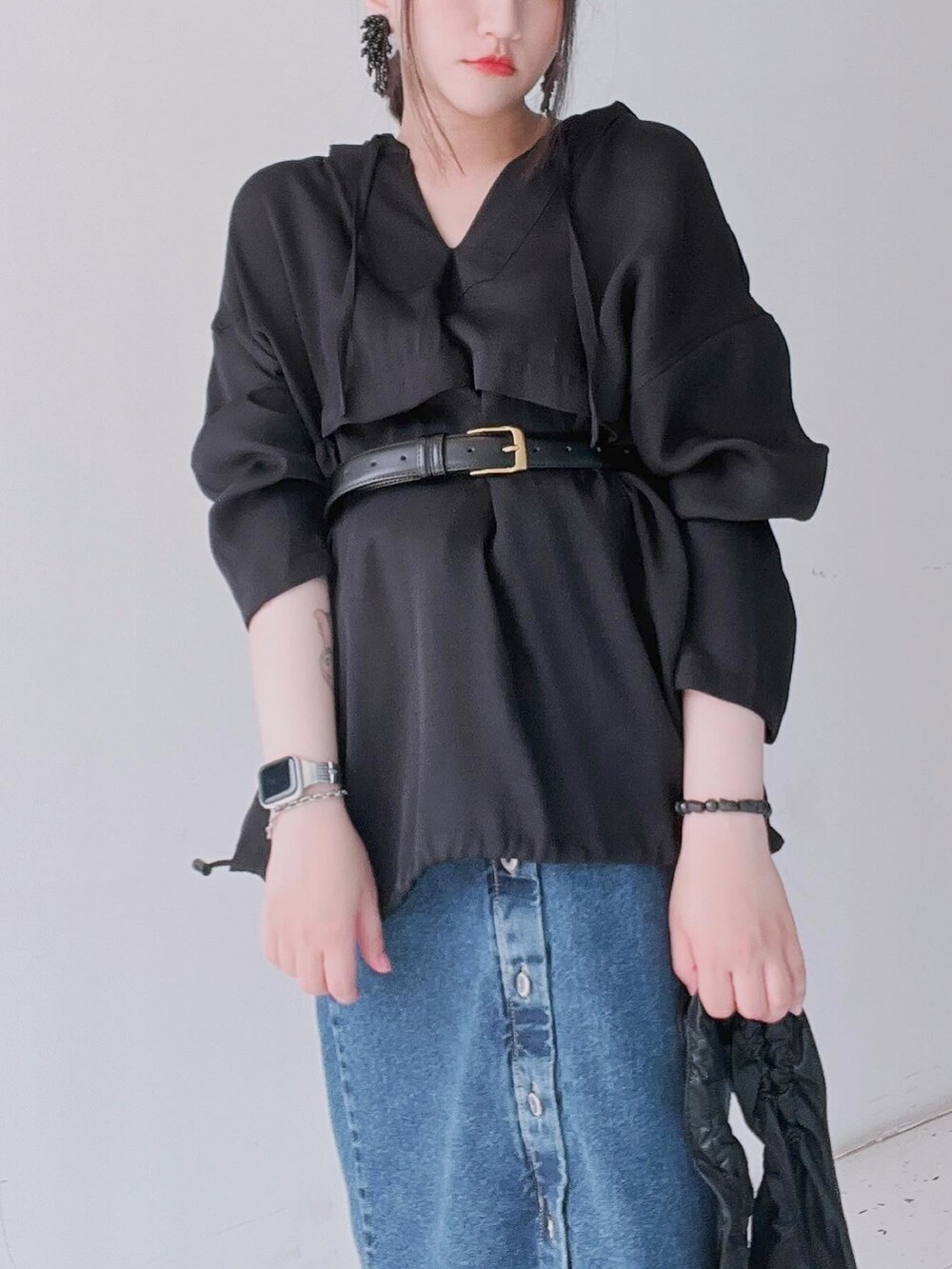 ブラック系のTシャツ/カットソー、ブルー系のデニムスカート、ブラック系のトートバッグを着用したレディースの春コーディネートの3枚目の写真