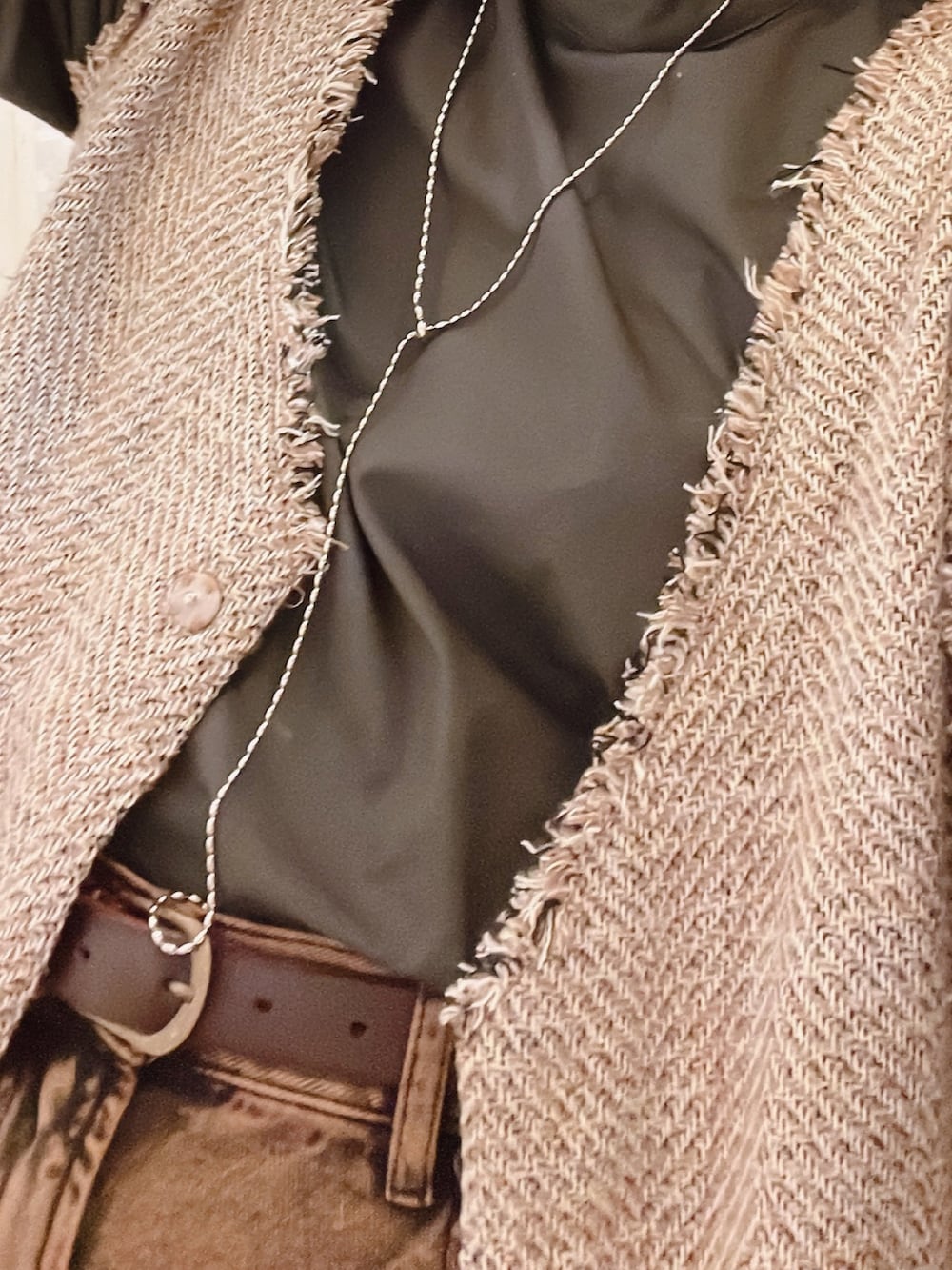 グレー系のシャツ/ブラウス、ベージュ系のベスト、シルバー系のイヤリングを着用したレディースの秋コーディネートの2枚目の写真