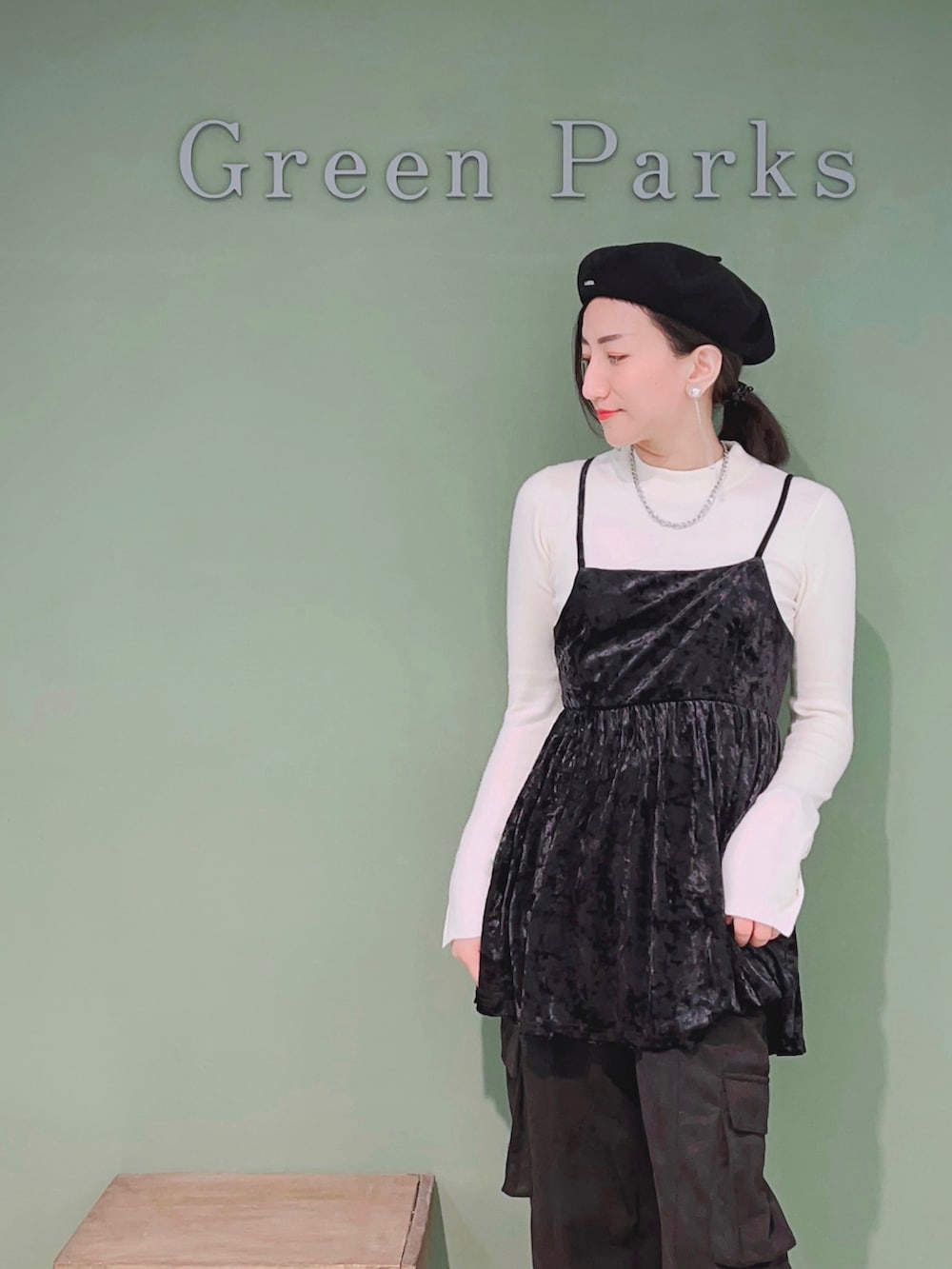 ブラック系のキャミソール、ブラック系のカーゴパンツ、ホワイト系のニット/セーターを着用したレディースの秋コーディネートの2枚目の写真