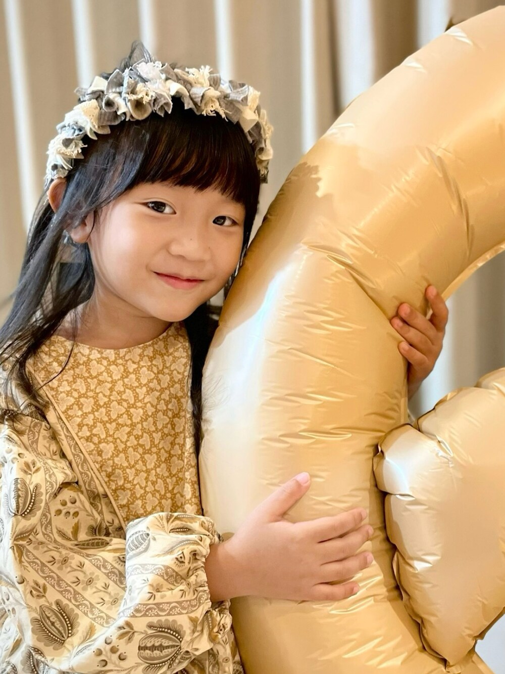 イエロー系のワンピース、グレー系のカチューシャを着用したキッズの秋コーディネートの3枚目の写真