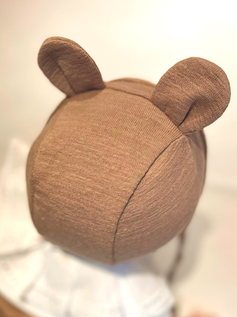 ブラウン系のその他ベビーウェア、ブラウン系のベビーパジャマ/スリーパー、ホワイト系のスタイ/よだれかけを着用したキッズの春コーディネートの3枚目の写真