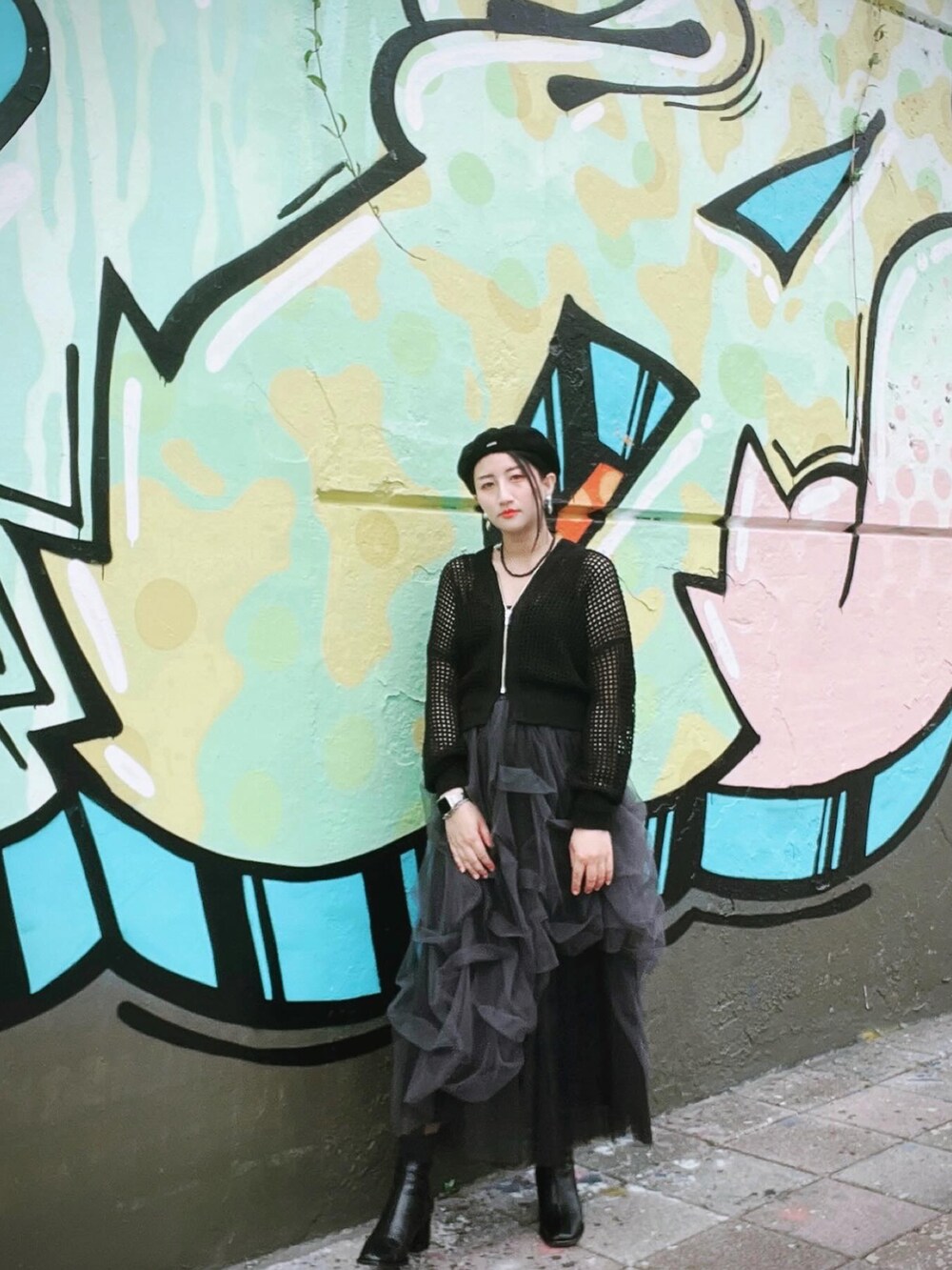 ブラック系のカーディガン/ボレロ、ブラック系のブーツ、ブラック系のハンチング/ベレー帽を着用したレディースの春コーディネートの3枚目の写真