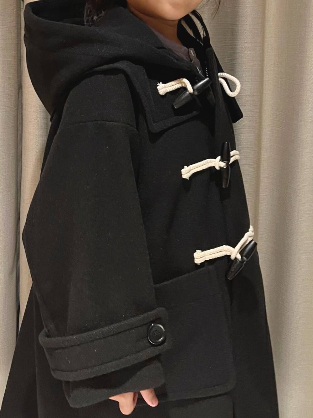 ブラック系のダッフルコートを着用したキッズの冬コーディネートの3枚目の写真