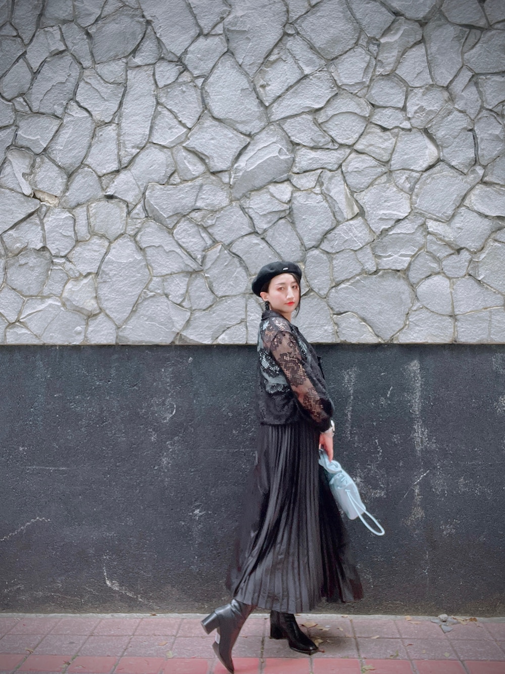 ブラック系のテーラードジャケット、ブルー系のハンドバッグ、ブラック系のイヤリングを着用したレディースの春コーディネートの3枚目の写真