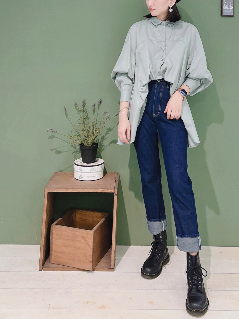 グレー系のチュニック、ブルー系のデニムパンツ、ブラック系のハンチング/ベレー帽を着用したレディースの秋コーディネートの2枚目の写真