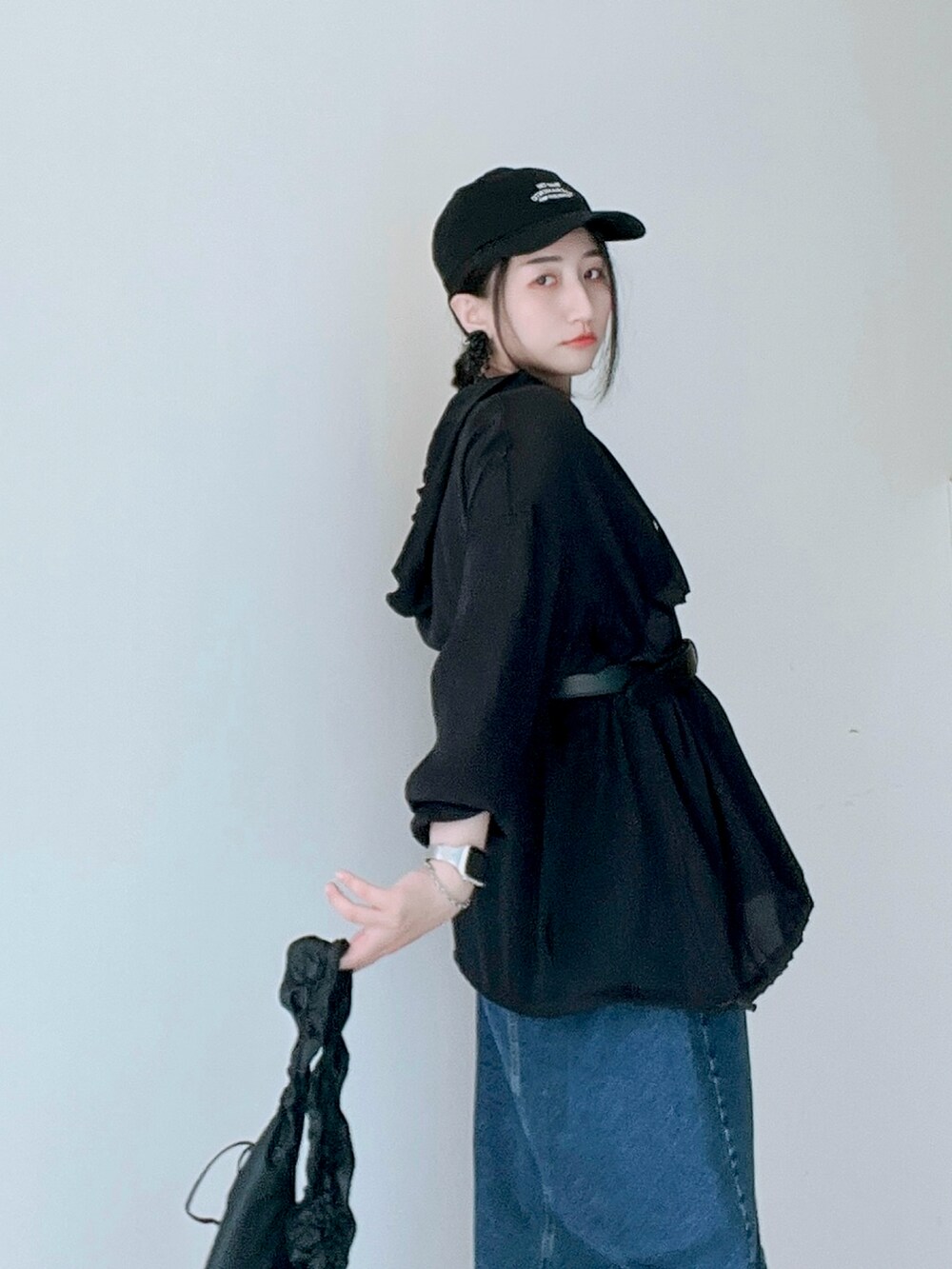 ブラック系のTシャツ/カットソー、ブルー系のデニムスカート、ブラック系のトートバッグを着用したレディースの春コーディネートの2枚目の写真