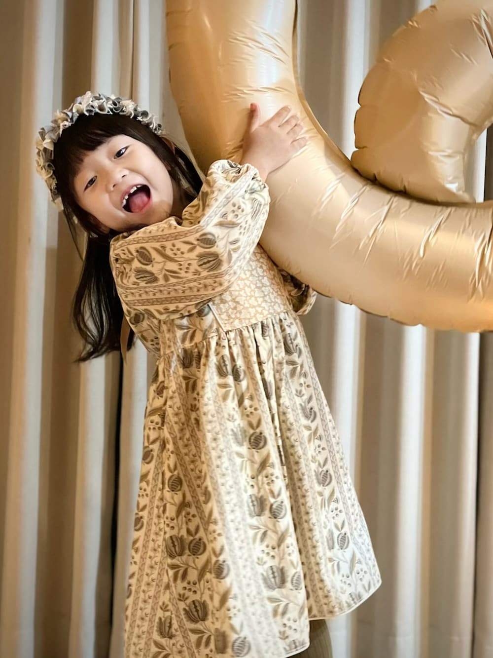 イエロー系のワンピース、グレー系のカチューシャを着用したキッズの秋コーディネートの2枚目の写真