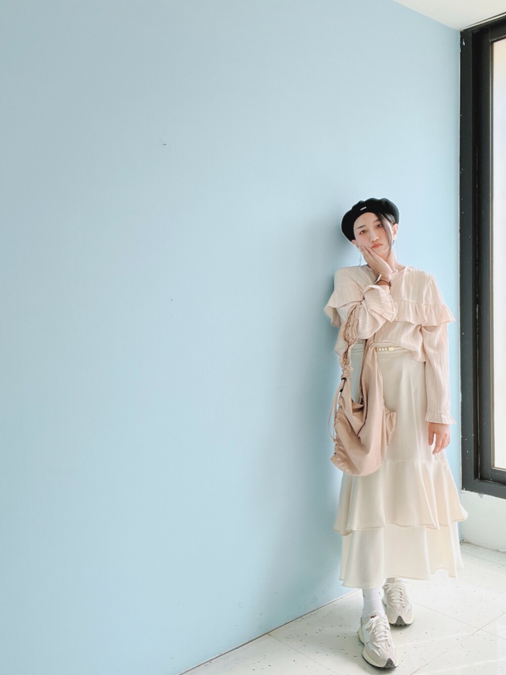 ピンク系のシャツ/ブラウス、ベージュ系のスカート、グレー系のスニーカーを着用したレディースの春コーディネートの2枚目の写真