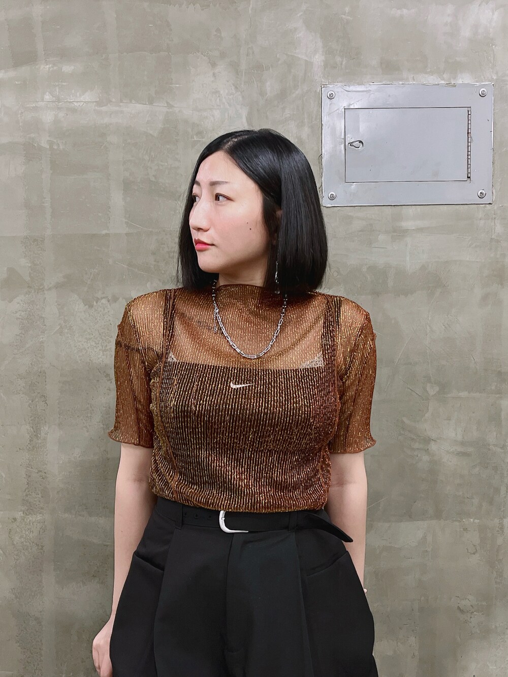 オレンジ系のTシャツ/カットソー、ブラック系のその他パンツを着用したレディースの秋コーディネートの3枚目の写真