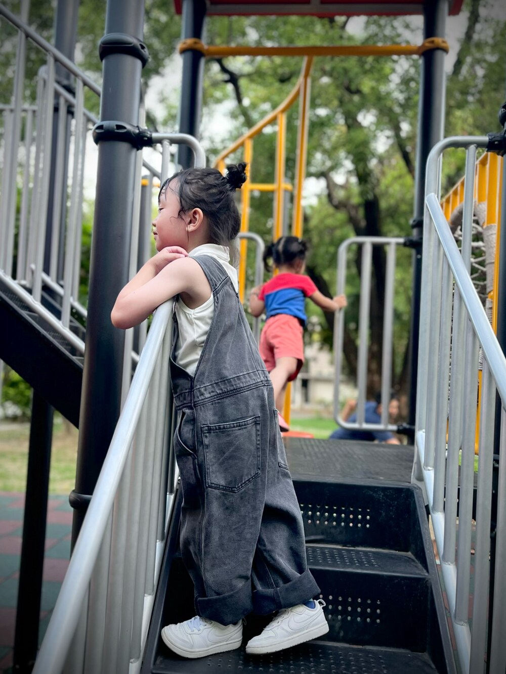 ブラック系のサロペット/オーバーオール、ホワイト系のスニーカーを着用したレディースの夏コーディネートの2枚目の写真