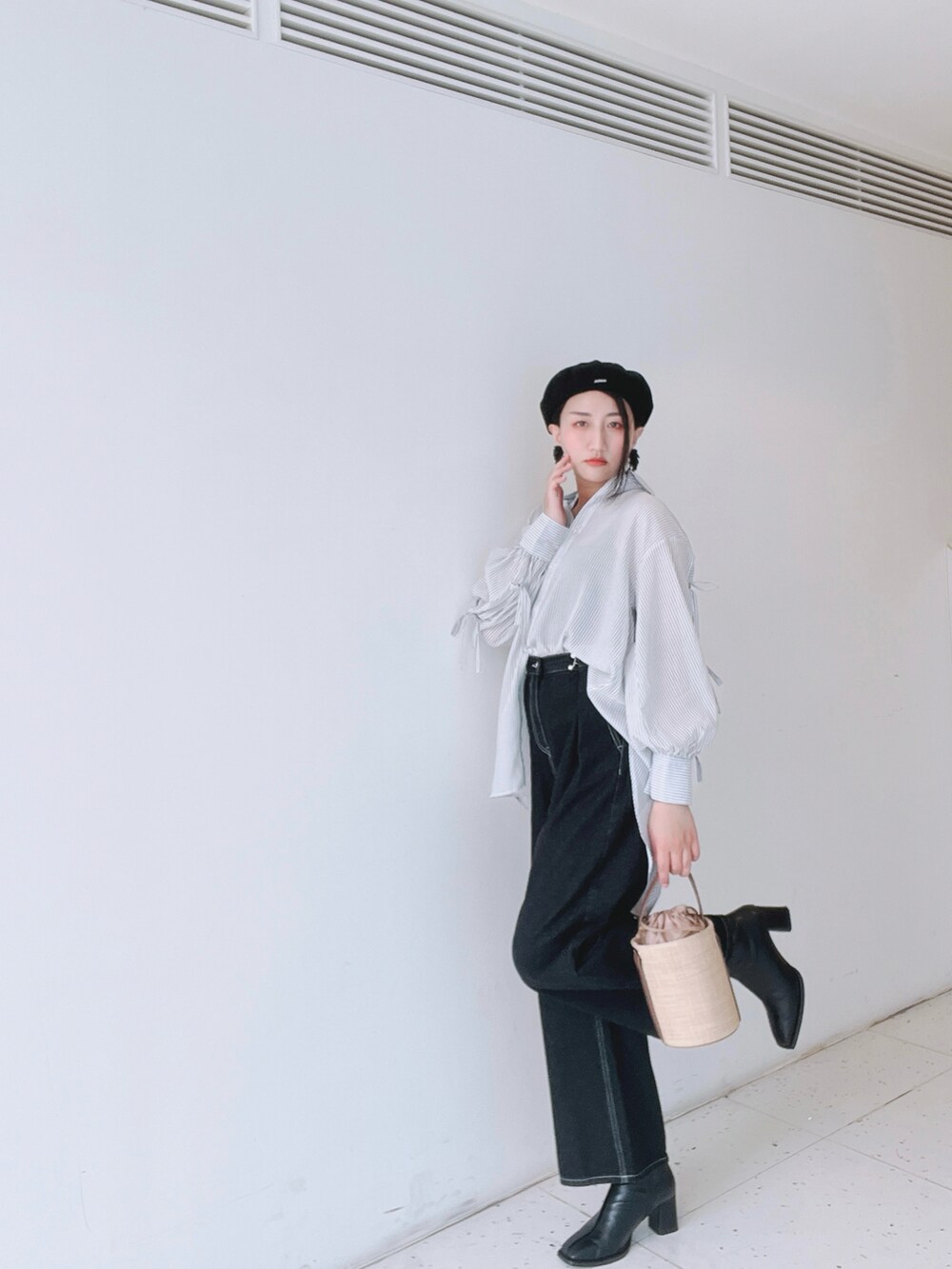 ブルー系のシャツ/ブラウス、ブルー系のデニムパンツ、ベージュ系のバッグを着用したレディースの春コーディネートの2枚目の写真