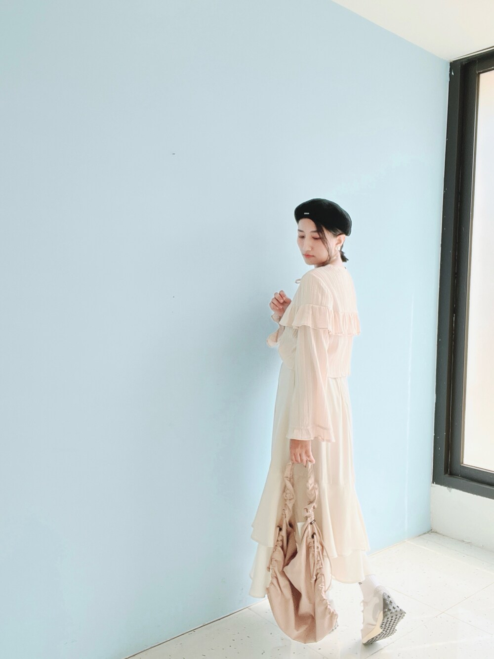 ピンク系のシャツ/ブラウス、ベージュ系のスカート、グレー系のスニーカーを着用したレディースの春コーディネートの4枚目の写真