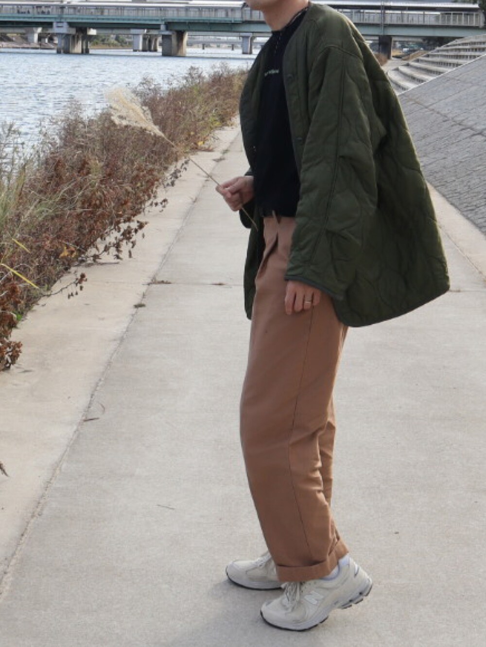 グリーン系のミリタリージャケット、グレー系のTシャツ/カットソー、ベージュ系のチノパンツを着用したメンズの秋コーディネートの2枚目の写真