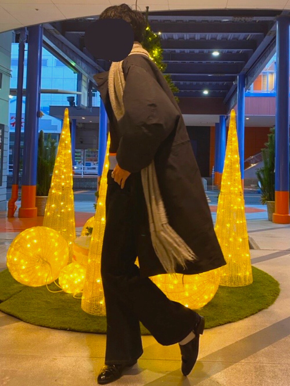 ブラック系のモッズコート、ブラウン系のベスト、ブルー系のデニムパンツを着用したメンズの冬コーディネートの2枚目の写真