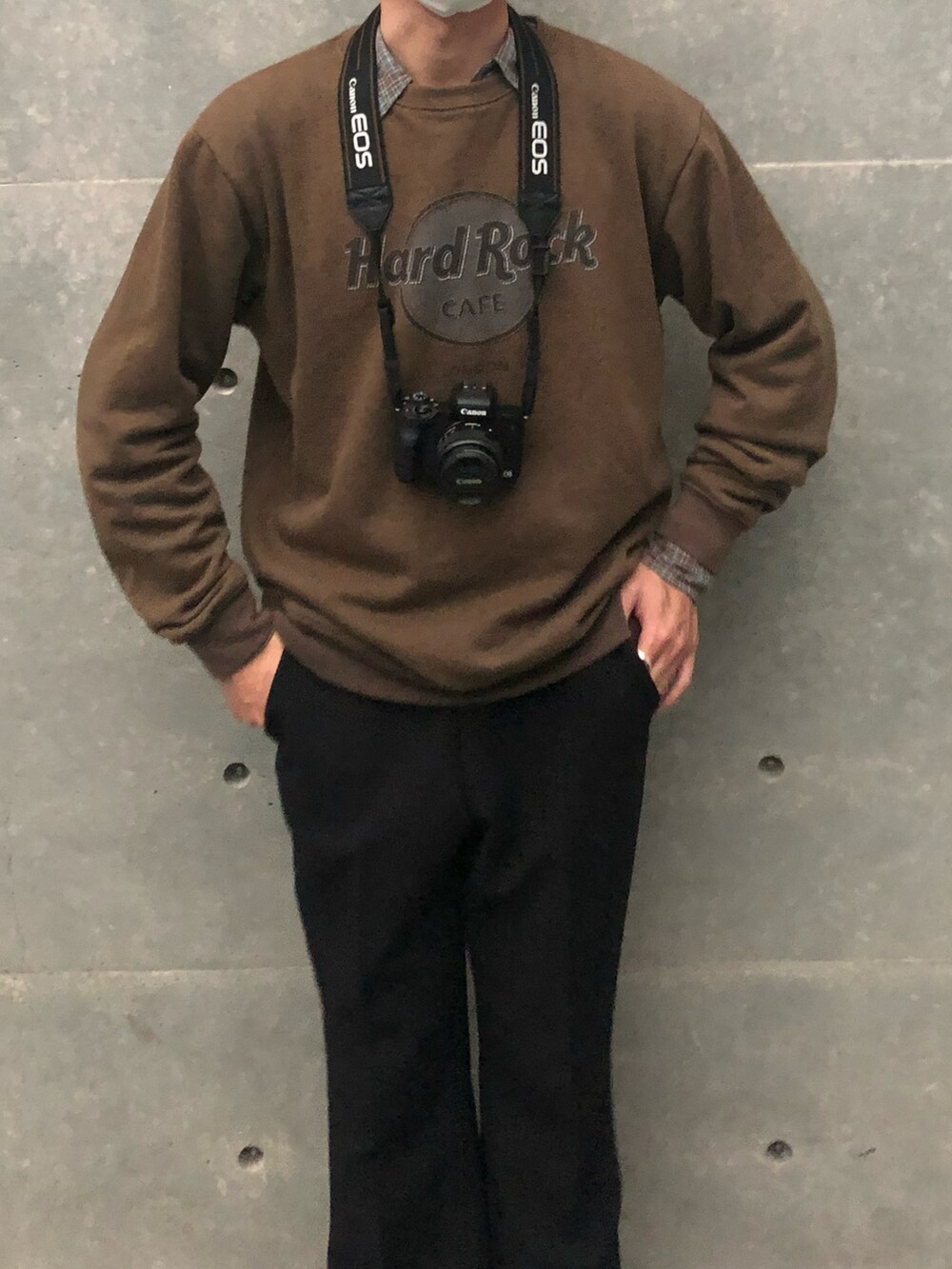 ブラック系のスラックス、ホワイト系のスニーカー、ブラウン系のスウェットを着用したメンズの冬コーディネートの2枚目の写真