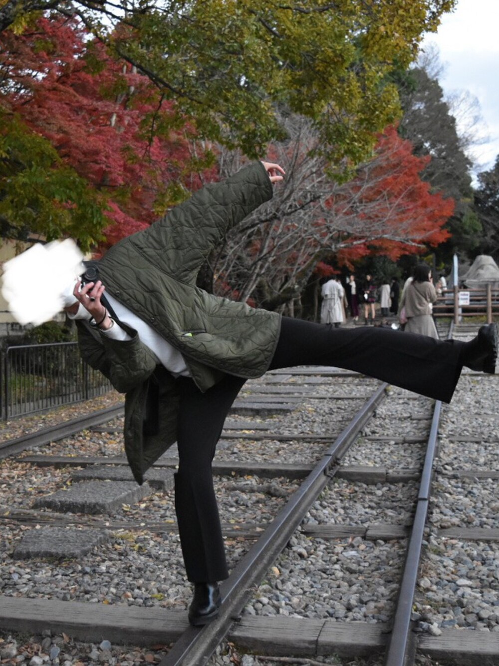 ブラック系のショルダーバッグ、ホワイト系のその他トップス、グリーン系のミリタリージャケットを着用したメンズの秋コーディネートの2枚目の写真