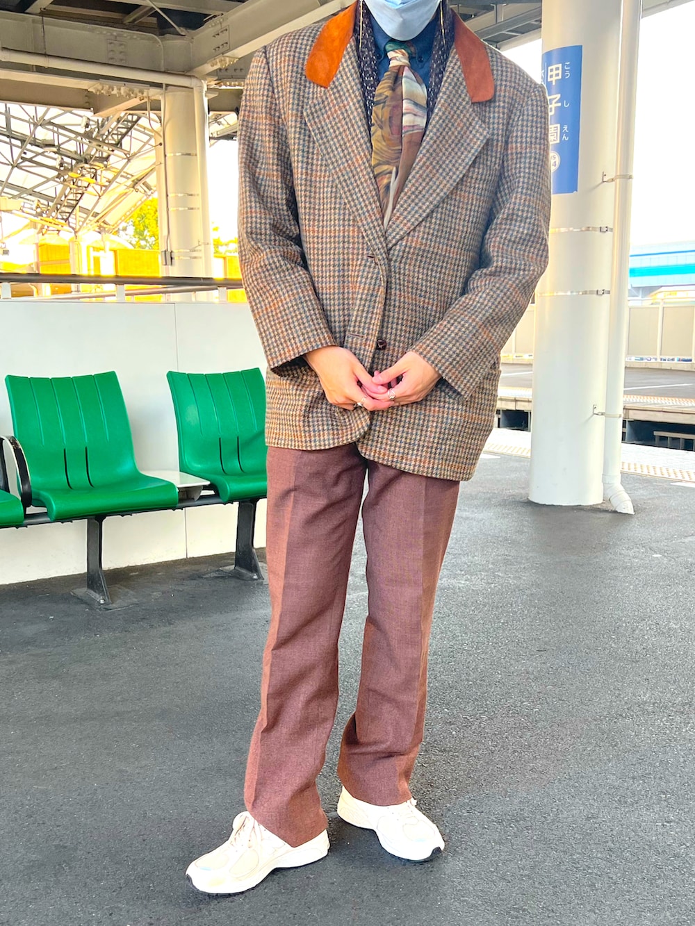 ベージュ系のスニーカー、ブラウン系のテーラードジャケット、ブラウン系のスラックスを着用したメンズの冬コーディネートの2枚目の写真