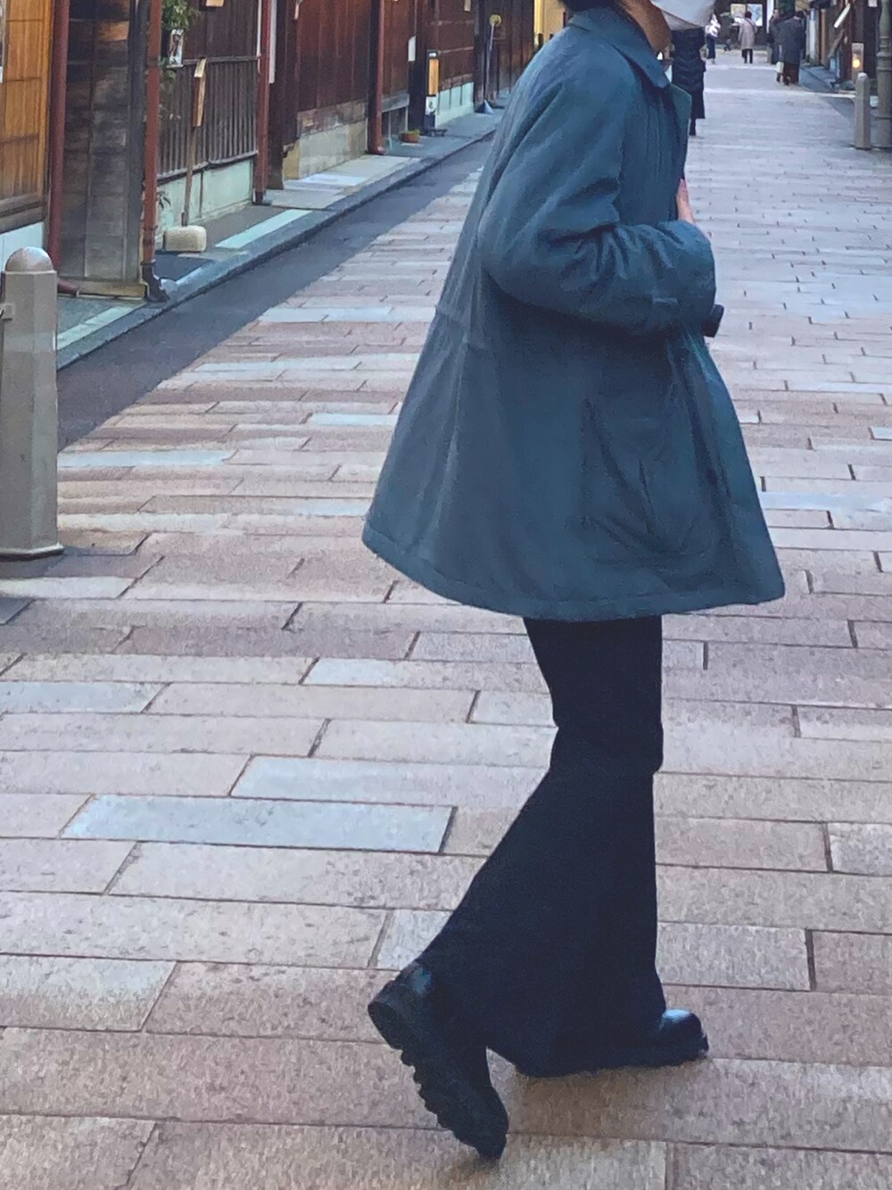 ブラック系のスラックス、ブラック系のブーツ、ブルー系のステンカラーコートを着用したメンズの冬コーディネートの2枚目の写真