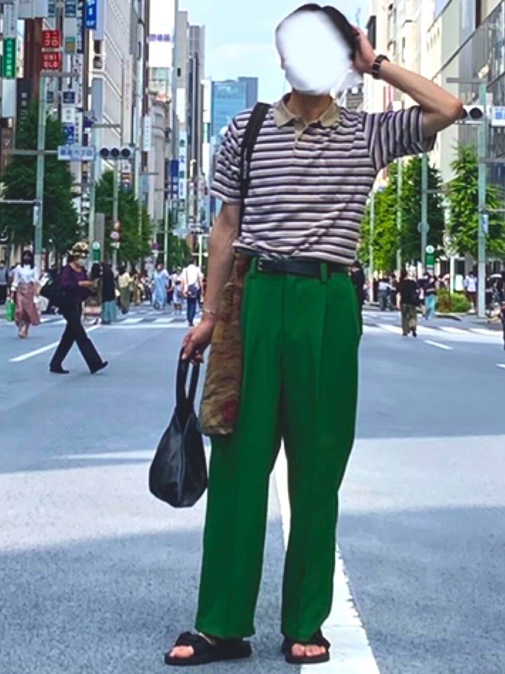 ベージュ系のポロシャツ、グリーン系のスラックス、ブラック系のハンドバッグを着用したメンズの春コーディネートの2枚目の写真