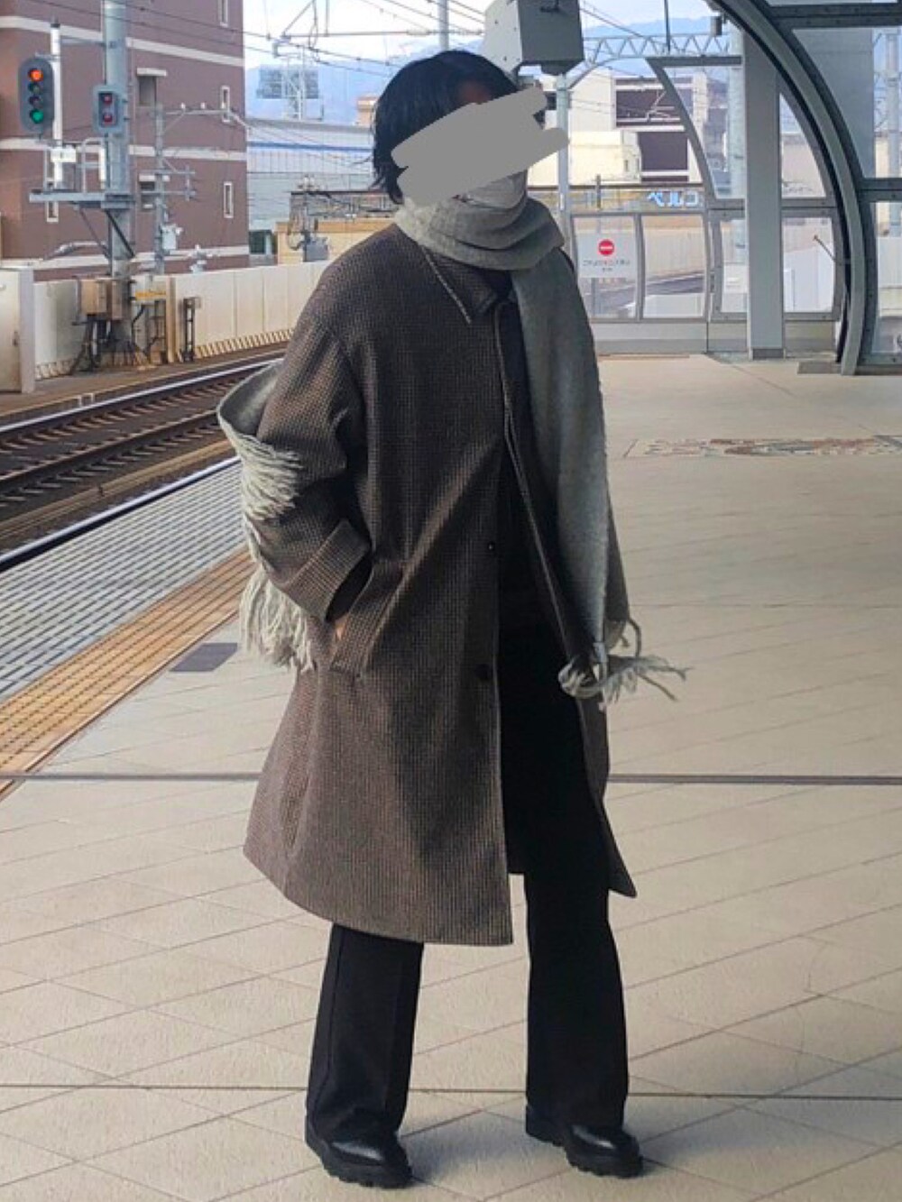 ブラウン系のステンカラーコート、ブラック系のブーツ、ブラック系のスラックスを着用したメンズの冬コーディネートの2枚目の写真