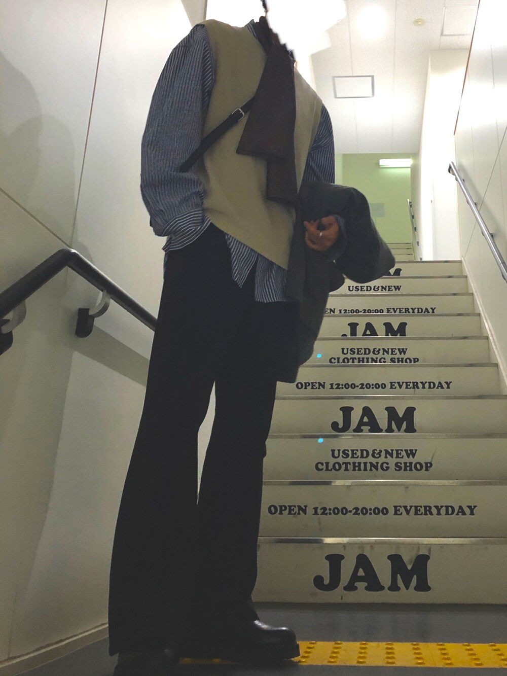 グレー系のピーコート、ブラック系のスラックス、ブラック系のブーツを着用したメンズの冬コーディネートの2枚目の写真