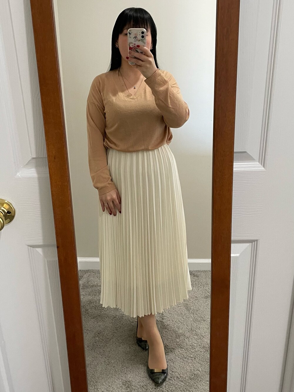 ベージュ系のダッフルコート、ベージュ系のニット/セーター、ホワイト系のスカートを着用したレディースの冬コーディネートの2枚目の写真