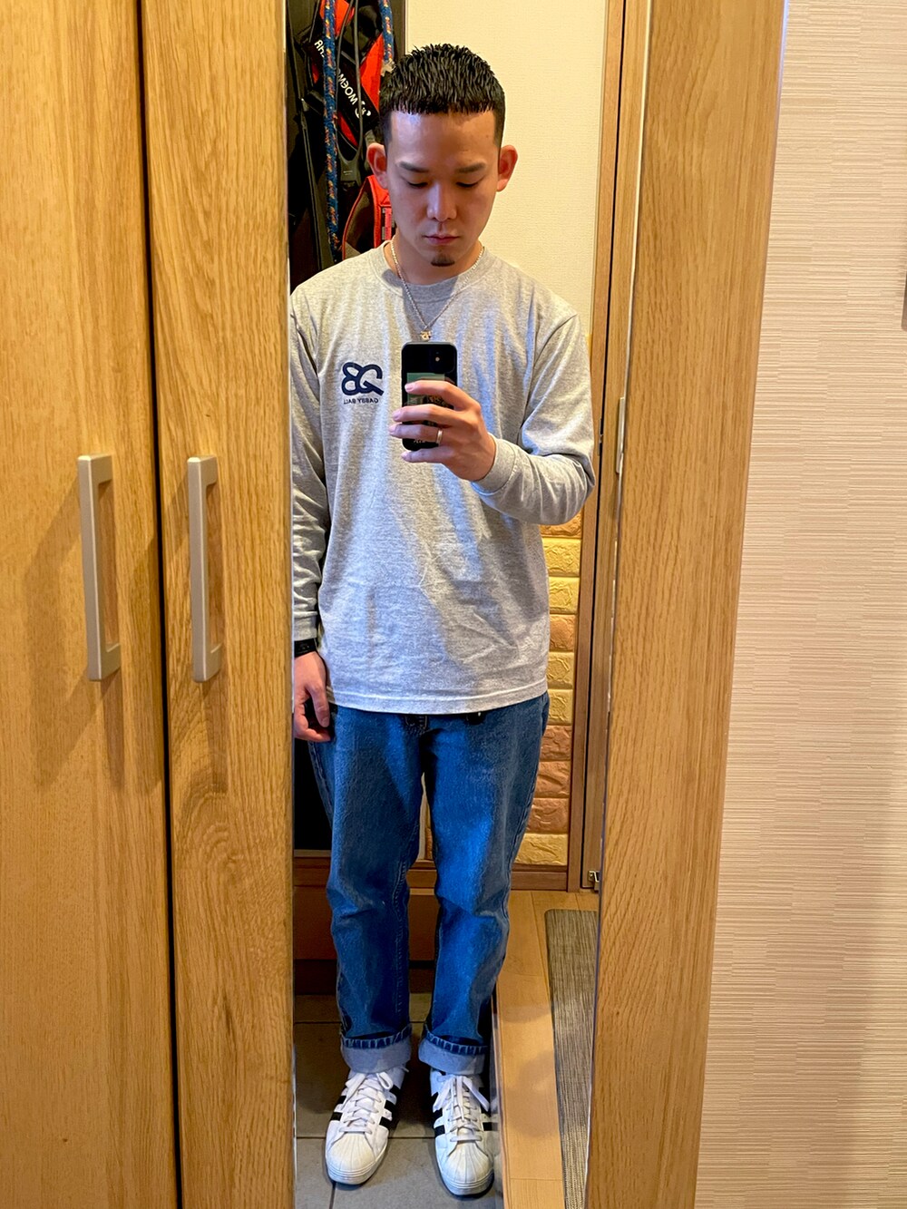 ブラック系のダウンジャケット/コート、ブルー系のデニムパンツ、ホワイト系のスニーカーを着用したメンズの冬コーディネートの2枚目の写真