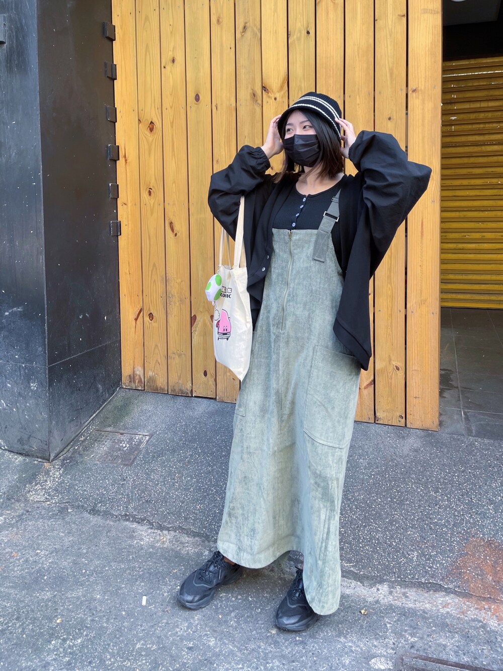 グリーン系のオールインワン・サロペット、ブラック系のジャケット/アウター、ブラック系のスニーカーを着用したレディースの春コーディネートの2枚目の写真