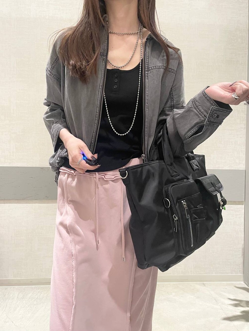 ブラック系のトートバッグ、ベージュ系のローファー、ブラック系のブルゾンを着用したレディースの春コーディネートの6枚目の写真
