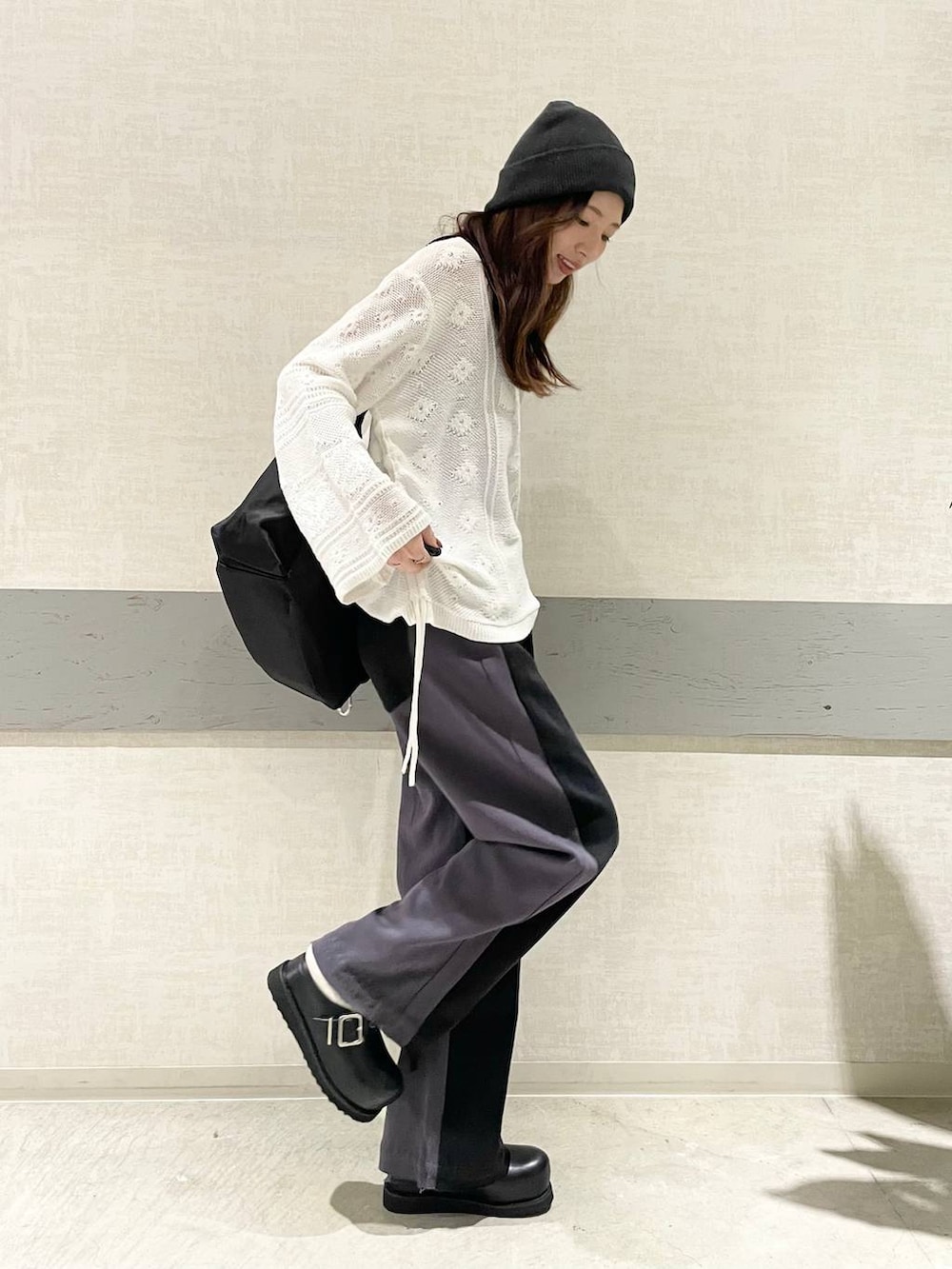 ブラック系のショルダーバッグ、ブラック系のその他シューズ、ブラック系のデニムパンツを着用したレディースの冬コーディネートの2枚目の写真