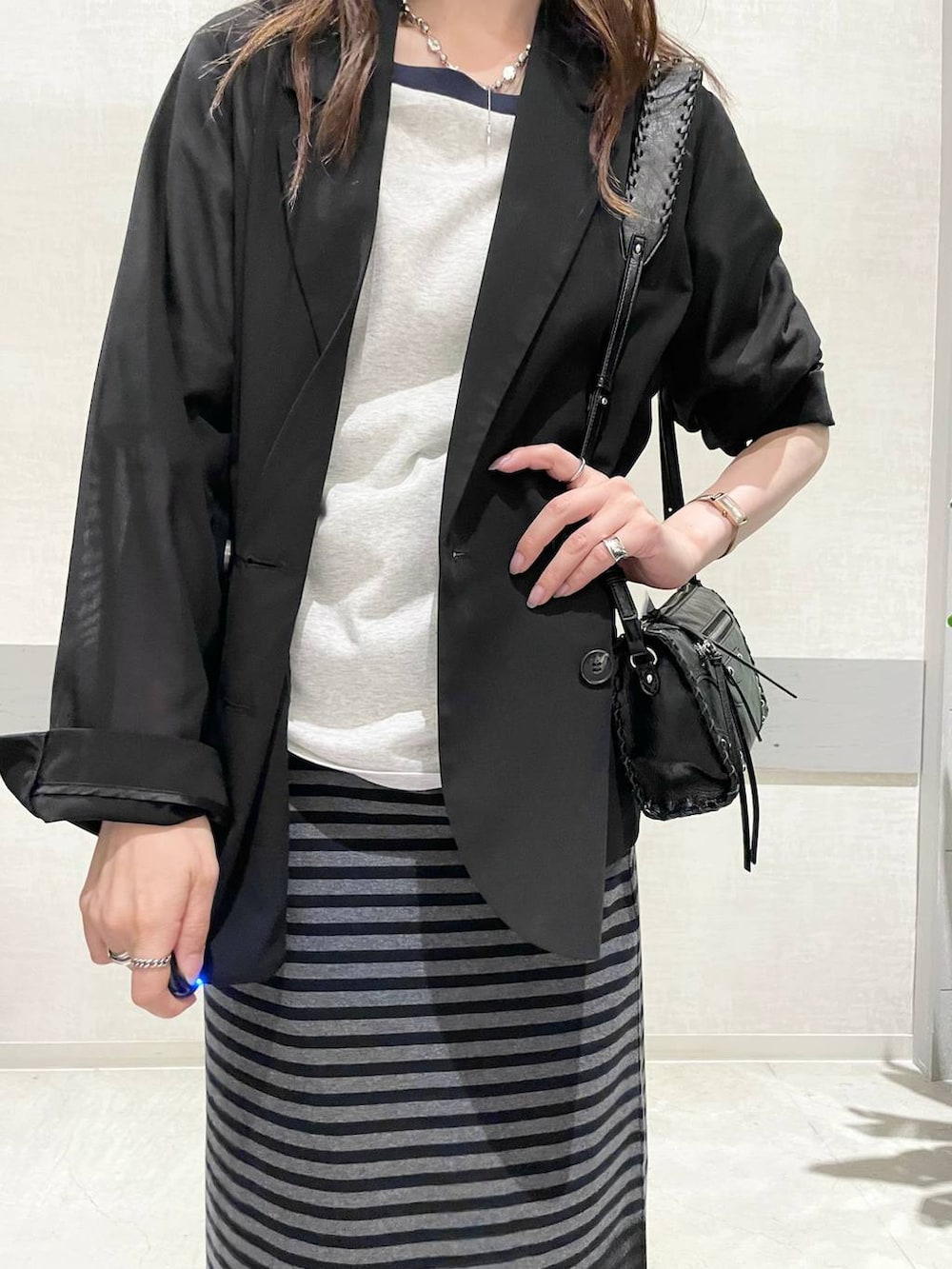 グレー系のTシャツ/カットソー、ブラック系のスカート、グレー系のサンダルを着用したレディースの夏コーディネートの4枚目の写真