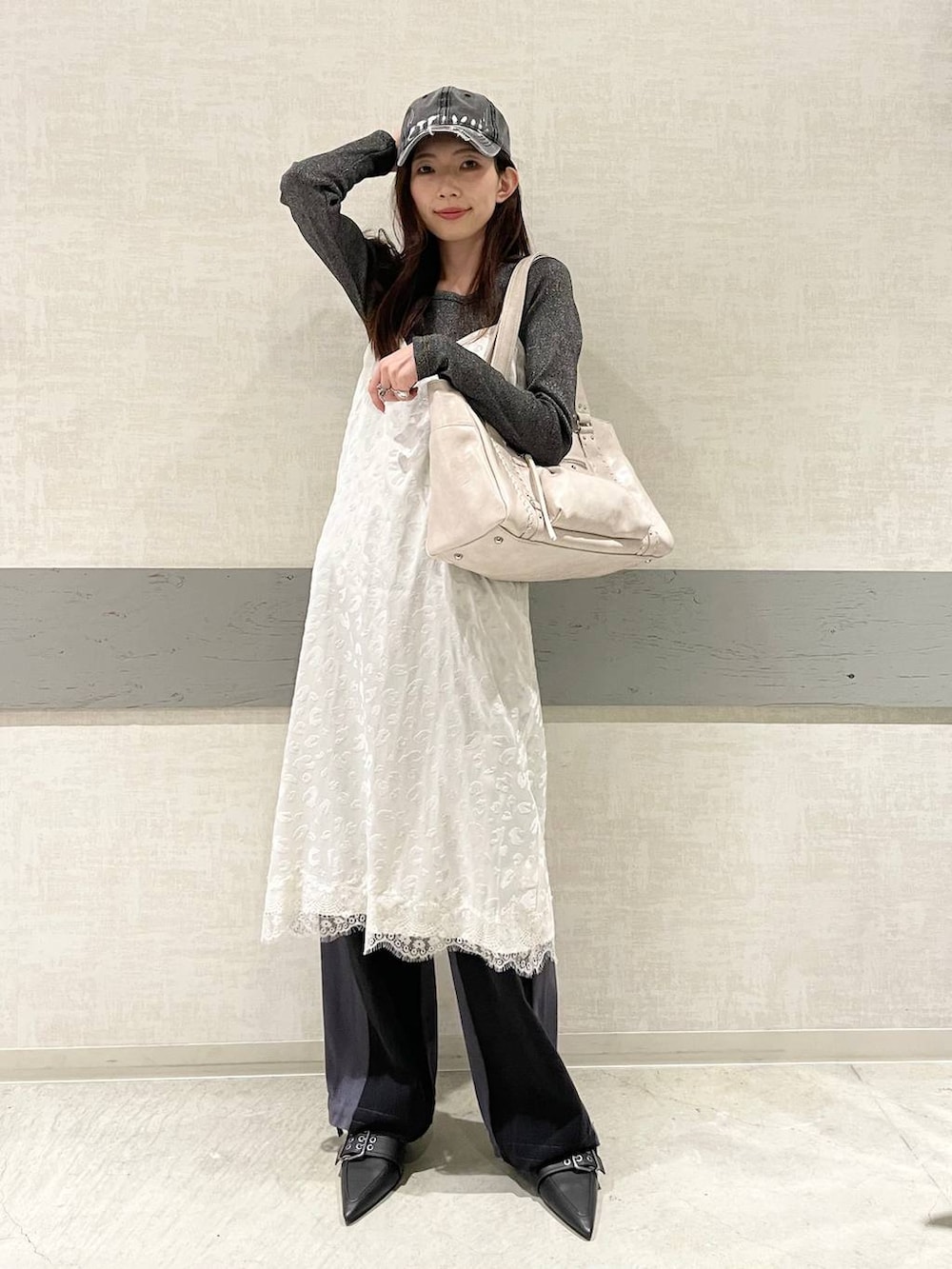 ブラック系のTシャツ/カットソー、ブラック系のパンプス、ホワイト系のトートバッグを着用したレディースの冬コーディネートの2枚目の写真