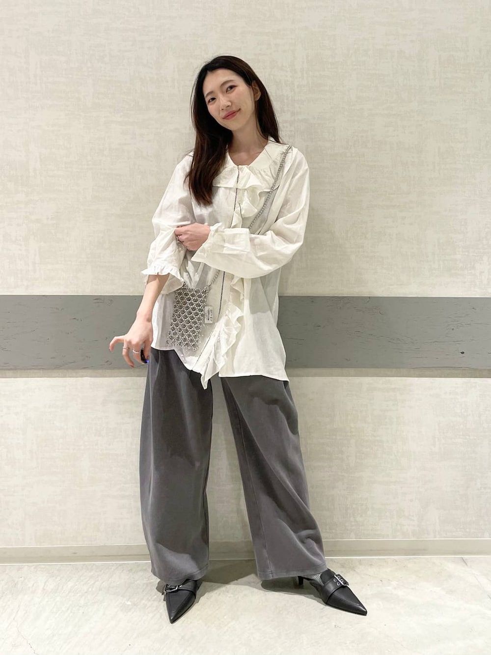 ブラック系のパンプス、グレー系のスウェットパンツ、ホワイト系のチュニックを着用したレディースの春コーディネートの2枚目の写真