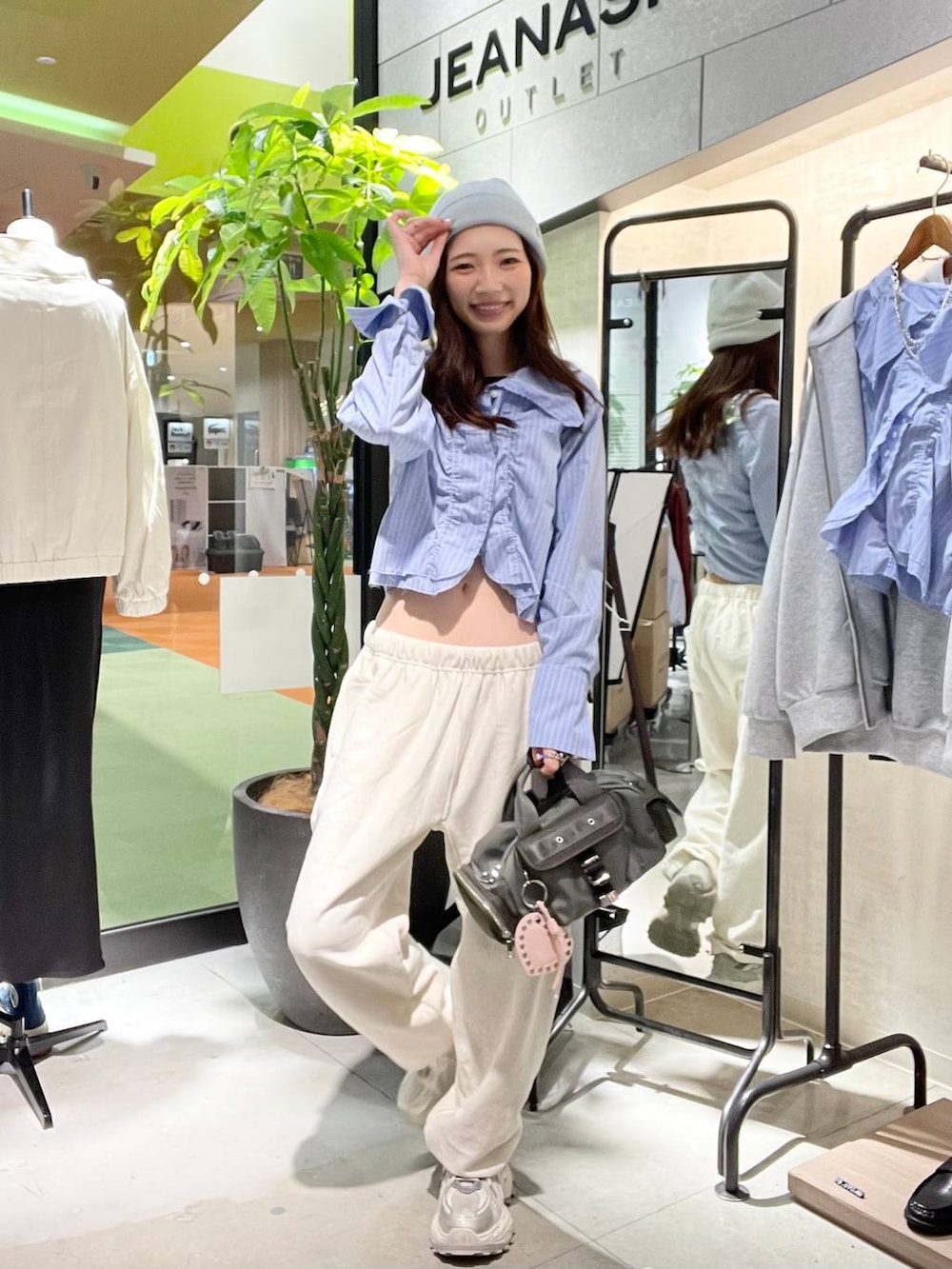 シルバー系のスニーカー、ベージュ系のスウェットパンツ、グリーン系のボストンバッグを着用したレディースの春コーディネートの2枚目の写真