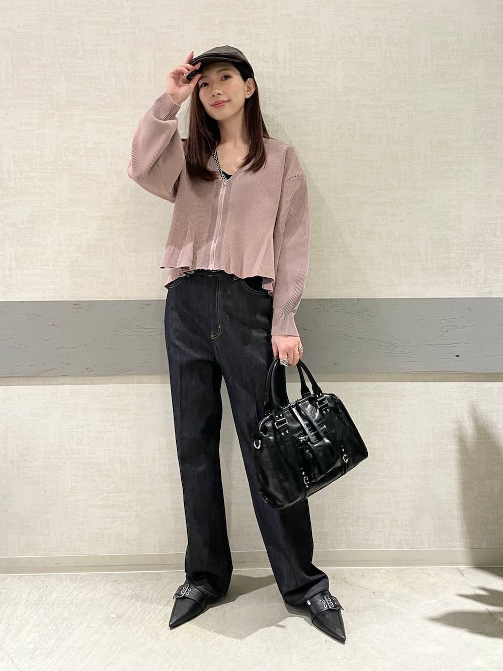 ブラック系のボストンバッグ、ブラック系のパンプス、ブルー系のデニムパンツを着用したレディースの冬コーディネートの3枚目の写真