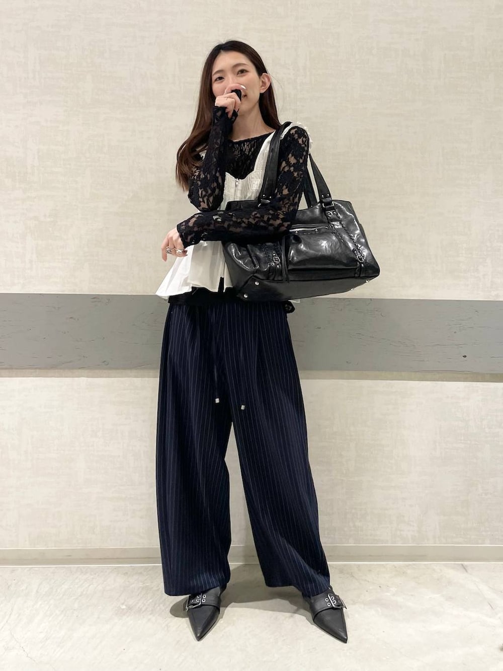 ブラック系のパンプス、ブルー系のスラックス、ブラック系のトートバッグを着用したレディースの春コーディネートの3枚目の写真