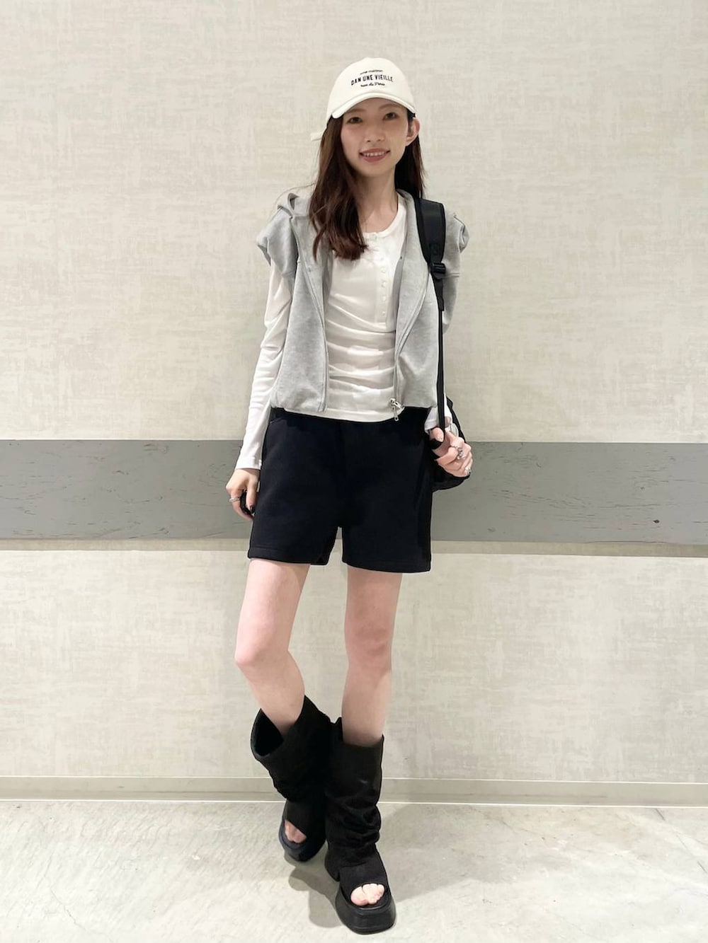 ホワイト系のTシャツ/カットソー、ブラック系のバックパック/リュック、ブラック系のスウェットパンツを着用したレディースの春コーディネートの2枚目の写真