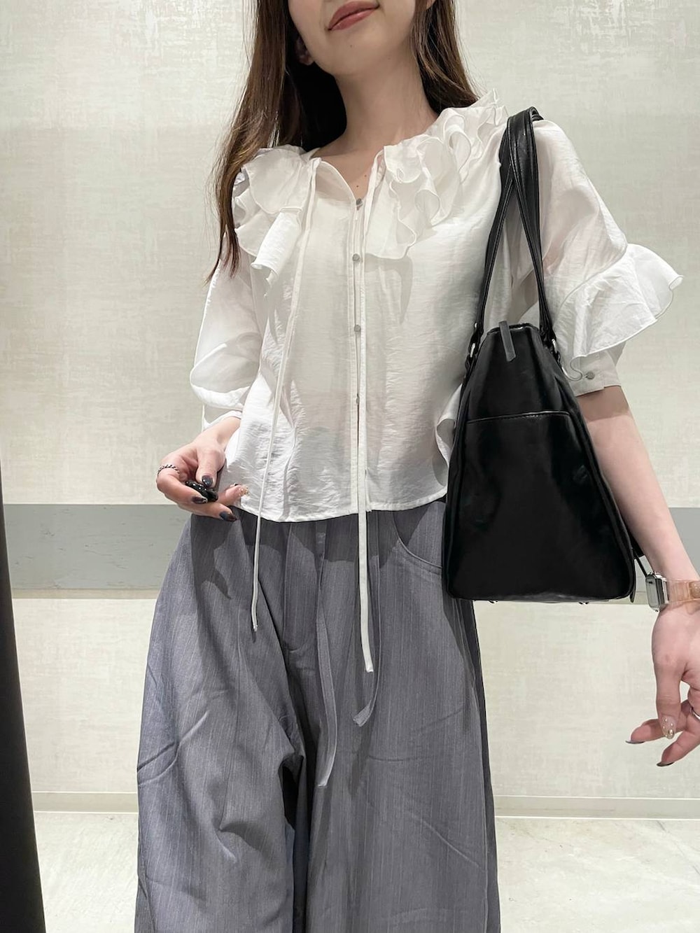 ブラック系のローファー、ブラック系のトートバッグ、グレー系のスラックスを着用したレディースの春コーディネートの4枚目の写真