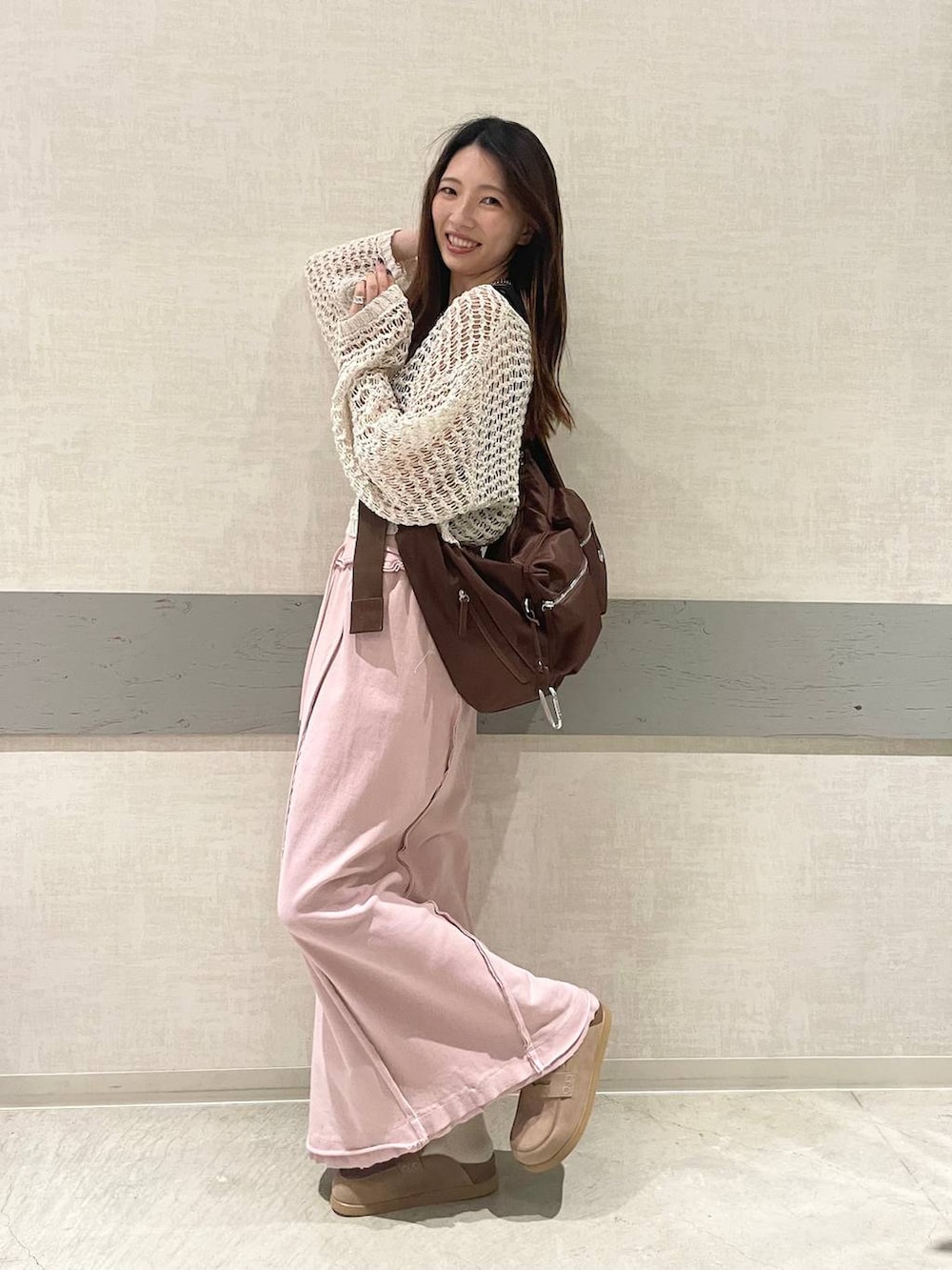 ブラウン系のショルダーバッグ、ベージュ系のローファー、グレー系のスカートを着用したレディースの春コーディネートの2枚目の写真