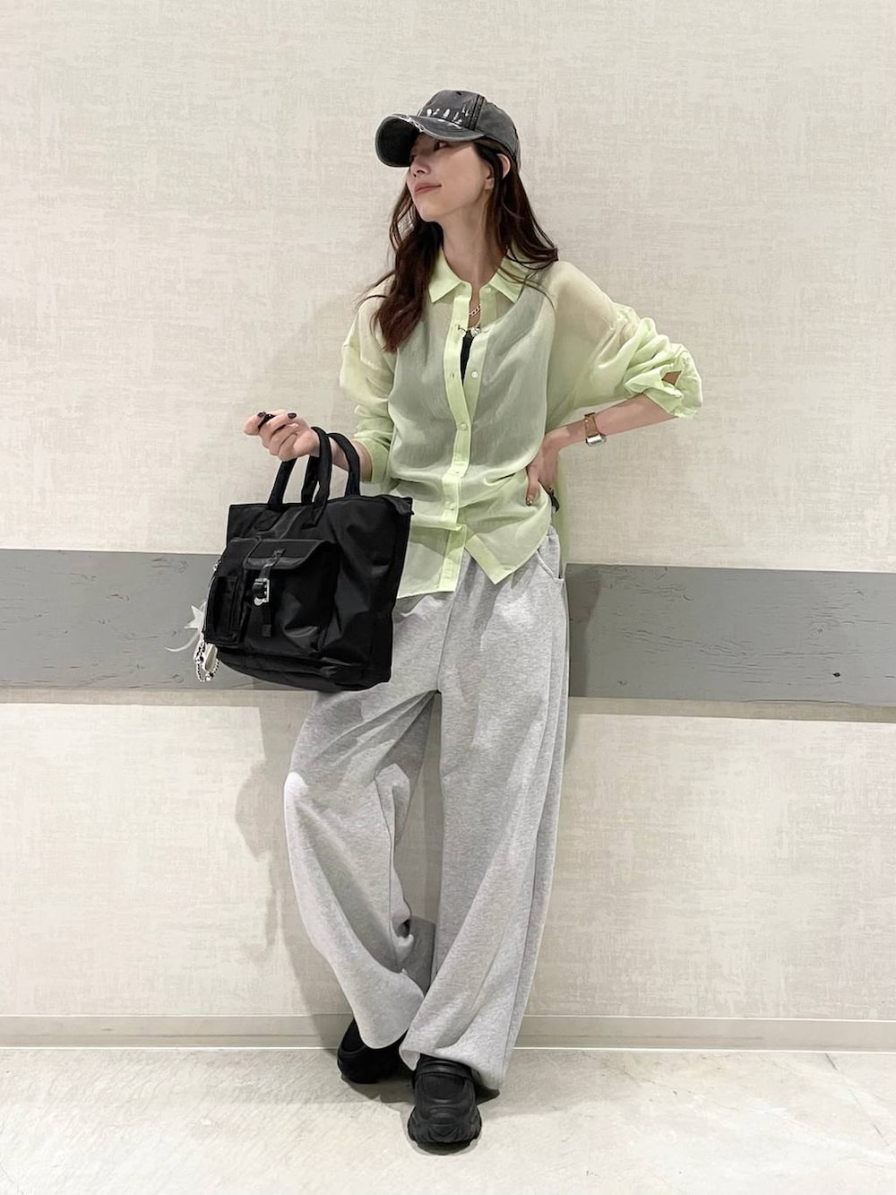 ブラック系のローファー、ブラック系のトートバッグ、グリーン系のシャツ/ブラウスを着用したレディースの春コーディネートの6枚目の写真
