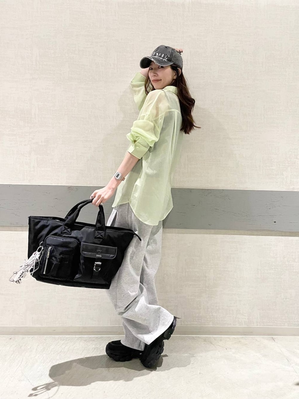 ブラック系のローファー、ブラック系のトートバッグ、グリーン系のシャツ/ブラウスを着用したレディースの春コーディネートの4枚目の写真