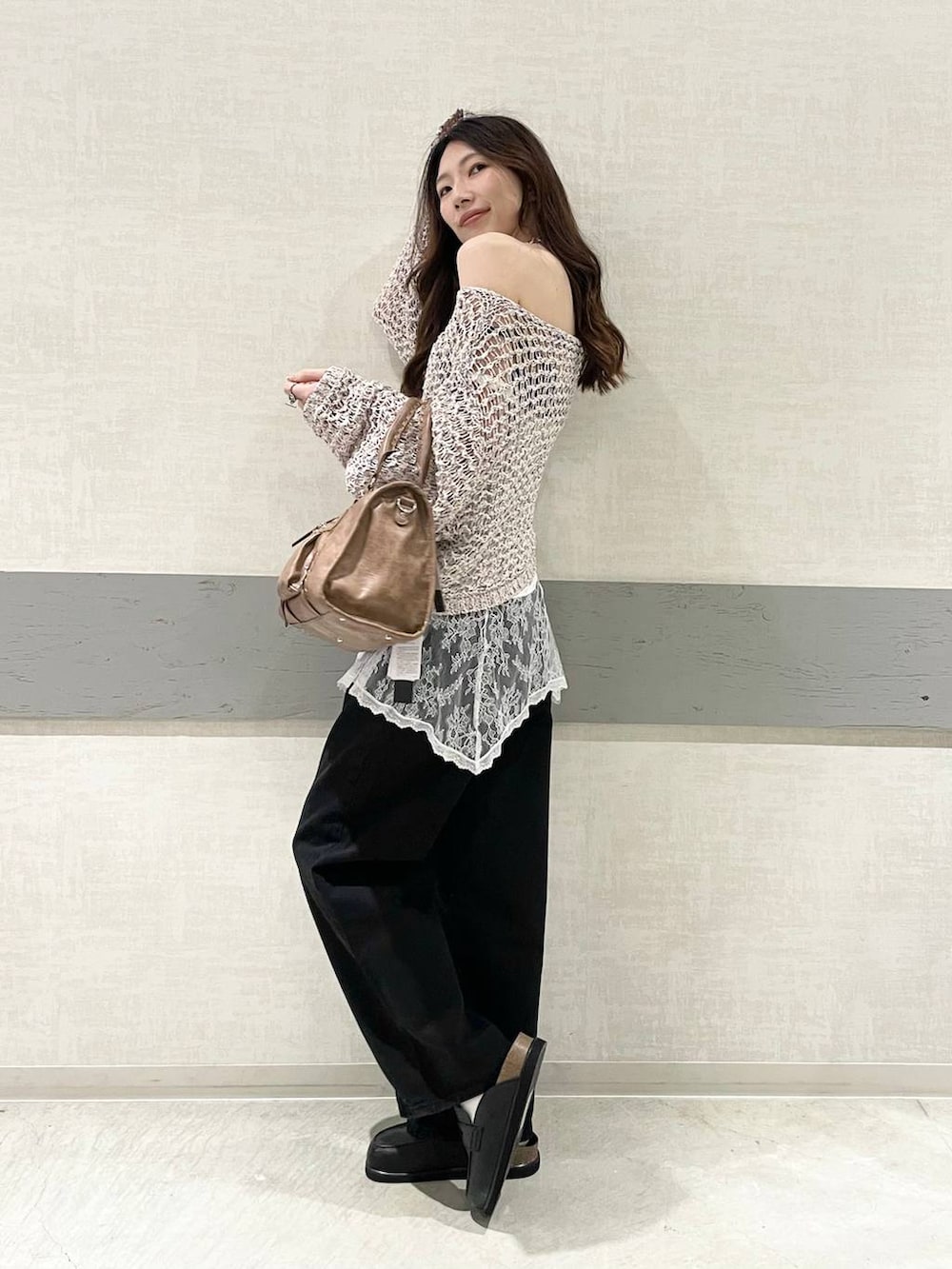 ブラック系のローファー、ブラック系のボストンバッグ、ブラック系のデニムパンツを着用したレディースの春コーディネートの3枚目の写真