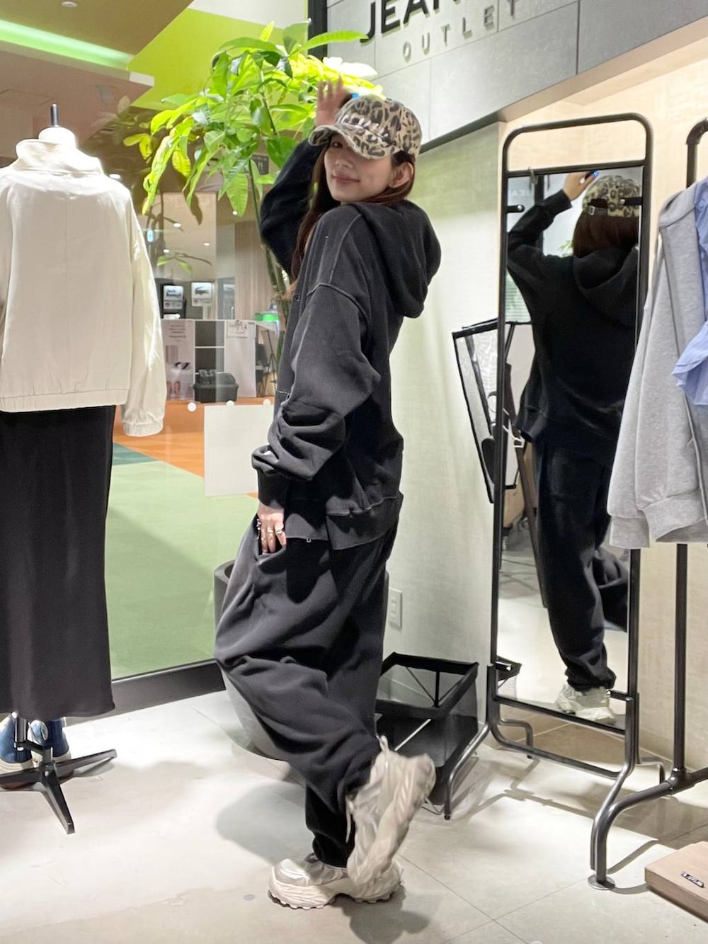 シルバー系のスニーカー、ブラック系のパーカー、ブラック系のスウェットパンツを着用したレディースの春コーディネートの3枚目の写真